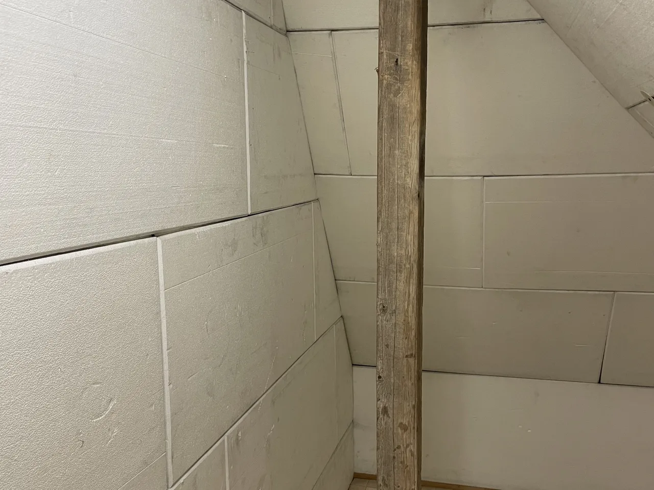 Eigenes Foto: Ausgebaute Dachschräge mit Dämmplatten zwischen und unter den Sparren und sichtbarem Holzbalken